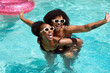 © Meeko Media - Two Black friends having fun in the pool, piggyback swimming laughing having fun