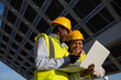© ADDICTIVE STOCK - Female engineers using laptop on construction site with solar panels