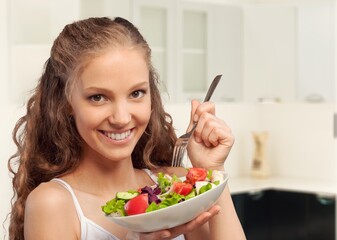 Wall Mural - Diet concept, young woman eat vegetables salad