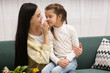 © New Africa - Happy woman with her daughter on sofa at home. Mother's day celebration