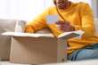 © New Africa - Young man holding greeting card near parcel with Christmas gift, closeup