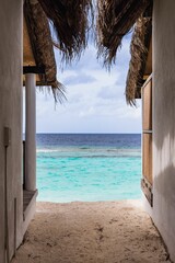 Sticker - Vertical shot of the tranquil ocean against a blue sky captured from the sandy beach in Maldives