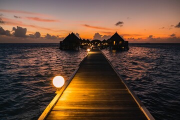 Wall Mural - Golden sunset over the beach with a boardwalk