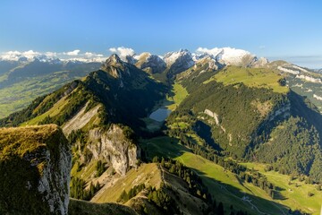 Canvas Print - Breathtaking view of evergreen mountains surrounding a tranquil lake against a blue sky