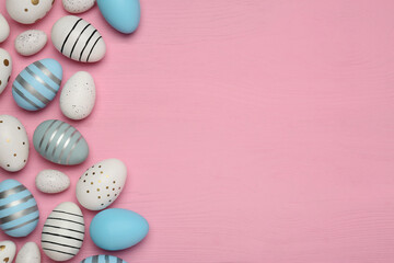 Wall Mural - Flat lay composition with festively decorated Easter eggs on pink wooden table. Space for text