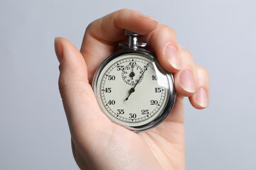 Wall Mural - Woman holding vintage timer on light grey background, closeup