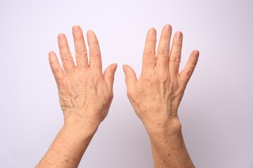 closeup view of older woman's hands on white background