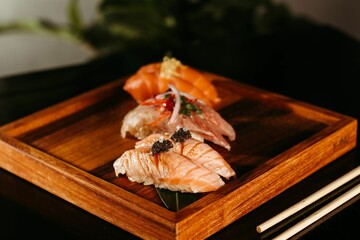 Poster - a piece of salmon and some black pepper sauce with chopsticks on a wooden