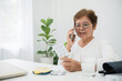 © 2April - Telemedicine concept, senior asian woman holding pill and using smartphone to call a doctor to listen to advice and make a diagnosis.