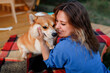 © bondvit - Happy young woman with Welsh Corgi Pembroke dog relaxing in glamping on summer day. Luxury camping tent for outdoor recreation and recreation. Lifestyle concept