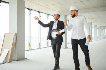 Happy workers at construction site, young civil engineer manager and architects. Indian and Arabian engineers.