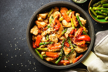 Wall Mural - Chicken stir fry with vegetables at stone background. Top view with copy space.