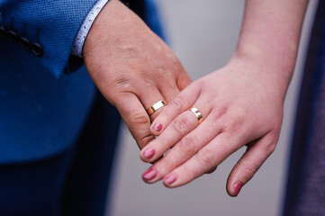 Wall Mural - Wedding gold rings on the hands of the newlyweds. Gold rings on the hand of a man and a woman