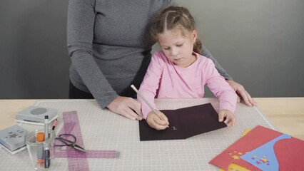 Sticker - Little girl making a handmade Father's Day card from construction paper.