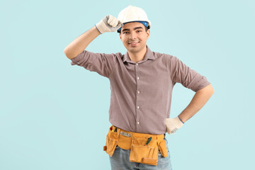 Poster - Young carpenter in hardhat on blue background