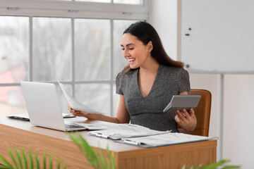 Poster - Female accountant working with document and calculator at table in office