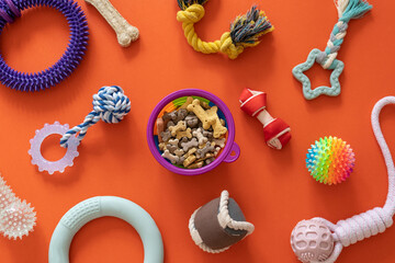 Wall Mural - Frame with dogs rubber and textile toys, snacks, bones on orange background. Close up. Accessories for dogs	