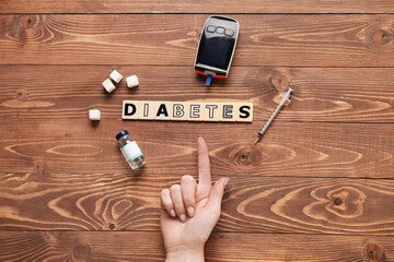 Wall Mural - Woman with digital glucometer, insulin and word DIABETES on wooden background