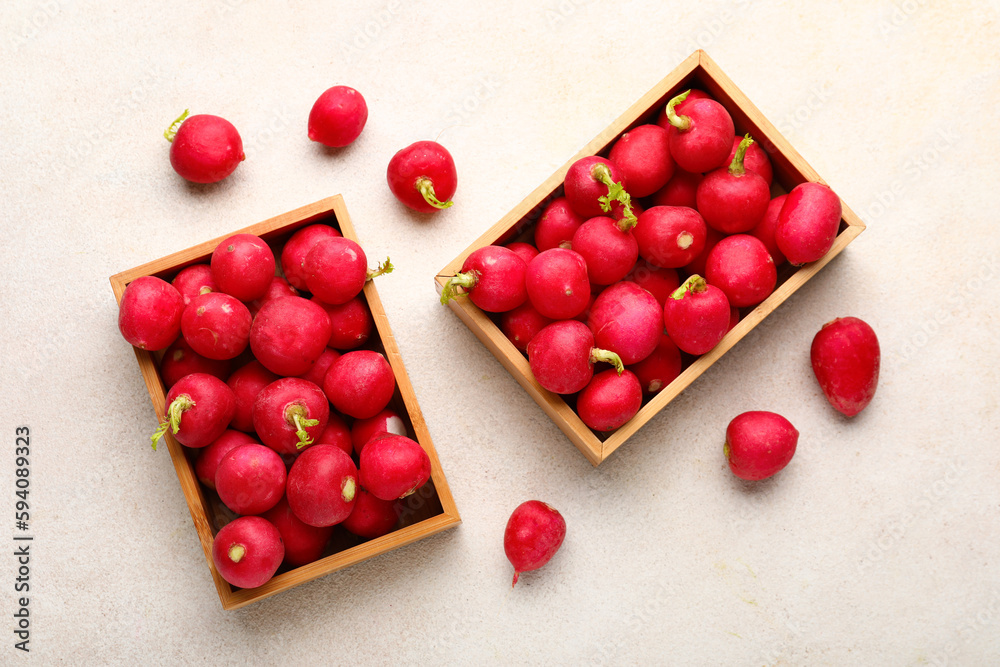 Wooden boxes with fresh radish on light background