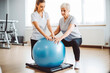 © VisualProduction - Full body shot of female physiotherapist doing exercises with elderly woman. Young asian physio therapist at the clinic. Generative AI.