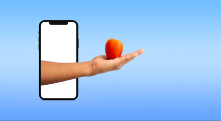 hand coming out of a cell phone holding a tomato