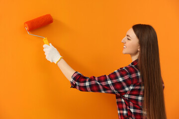 Wall Mural - Happy designer painting orange wall with roller