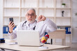 © Elnur - Old male doctor in telemedicine concept