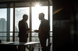 © MVProductions - Two businessmen discussing a project in a office with morning sun shining through the window. High quality generative ai