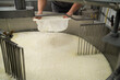 cheese production and storage of dairy. Cheese factory employee separation of curd from whey in a local factory.
