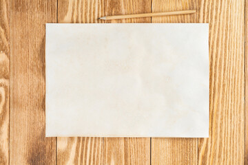 Wall Mural - Sheet of paper lying on wooden table