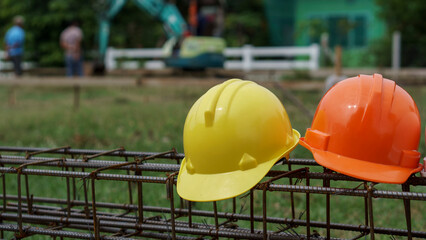 Wall Mural - orange and Yellow Safety helmet (hard hat) for engineer, safety officer, or architect, place on Stainless Steel wire Rolls and wire mesh Metal Steel reinforced rod for concrete on construction site wi