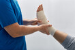 © Peakstock - Doctor wrapping male patient's foot with elastic bandage for treat muscle sprains in doctor's office of medical clinic