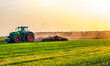 a tractor in a field under the sunlight of dawn plows a field. High quality photo