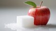 Ein roter, saftiger Apfel neben einem weißen Zuckerwürfel vor weißem Hintergrund, Generative AI