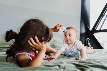 Wall Mural - latin Little sister with her baby brother at home in Mexico Latin America, hispanic family