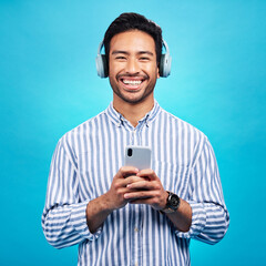 Aufkleber - Music, headphones and happy man with phone in studio for streaming, audio and subscription against blue background. Radio, smile and face of asian male online for podcast, track and internet app