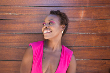 Young and beautiful Afro American woman doing different postures and expressions on a wooden background. The woman is smiling, sad, happy, joyful. Concept different postures and expressions.