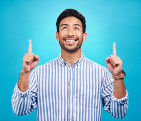 Poster - Man is pointing up, marketing and promotion with happiness and branding isolated on blue background. Opportunity, deal or announcement with advertising, news and promo ad with male person and smile