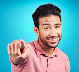 Poster - Pointing, you and portrait of man. in studio for motivation, choice and decision. Happy, smile and yes with male and hand gesture isolated on blue background for option, offer and emoji mockup