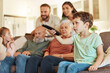 © J Bettencourt/peopleimages.com - Grandparents, family tv and children in a home living room streaming a web series together. Senior people, kids and television remote watching a video on a lounge couch with a child film and movie