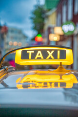 Canvas Print - Yellow Taxi sign over a car in Reykjavik, Iceland