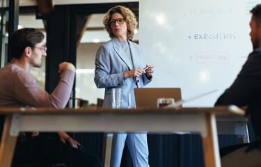 Wall Mural - Professional woman having a discussion with her team in a meeting