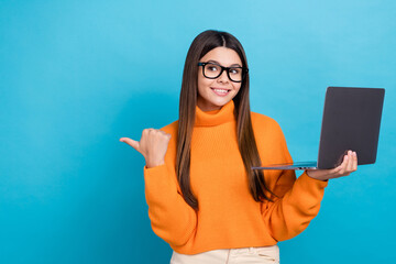 Wall Mural - Portrait of charming positive girl hold netbook look direct finger empty space isolated on blue color background