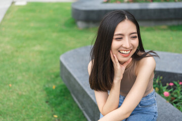 Happy feeling of Beautiful Young Woman smiling outdoor in sunlight. Pretty attractive face of female and beautiful smile. She is positive thinking and successful.