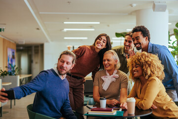 Coworkers take casual selfie in cafeteria.