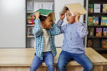 Wall Mural - Two African American children are reading book, studying at school and having fun. Back to school.