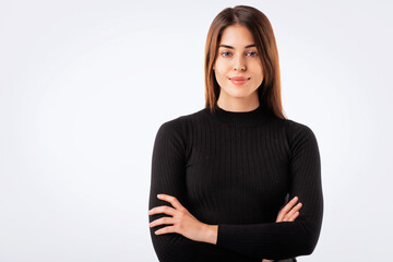 Close-up of confident young woman with folded arms against white background