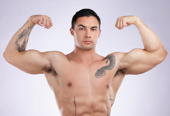 Wall Mural - Fitness is definitely my business. a young male athlete flexing his biceps against a grey studio background.