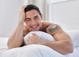 Sticker - Smile like you mean it. a handsome young man lying in bed.