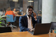© JustLife - Portrait of successful businessman in office. Young smiling man talking to the phone..